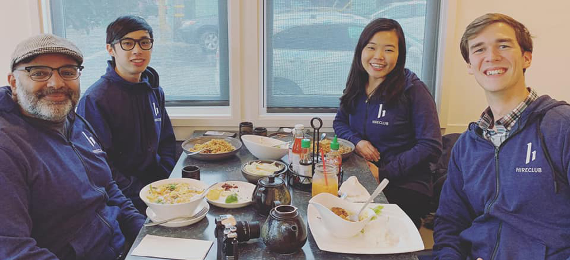 Team lunch at HireClub with logo-printed hoodies.